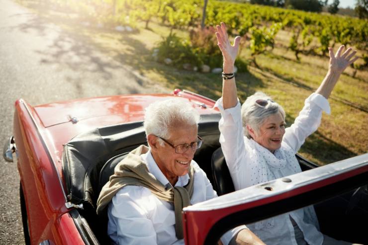 Una coppia di anziani felici in auto